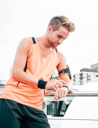 Young attractive guy using wearable fitness gear