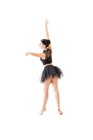 Young attractive ballerina performing alternate dance moves isolated on white backgroundの写真素材