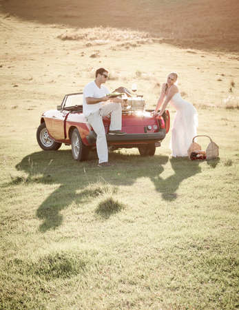 couple in a grass field having a picnic outdoors.の写真素材
