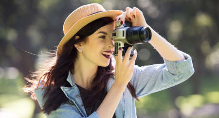 Young happy traveler exploring surrounds with film camera