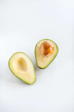 Avocado cut in half with pit seed on white backgroundの写真素材