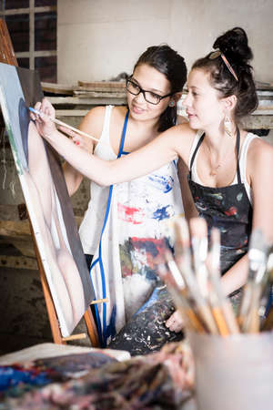 two young artists working together on a paintingの写真素材