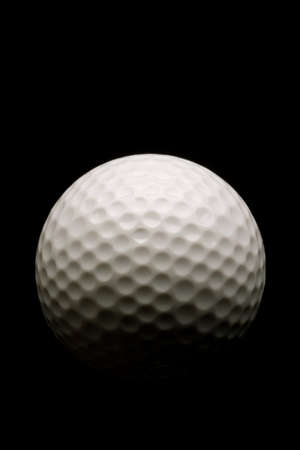 Golf ball with dramatic lighting on black backgroundの写真素材