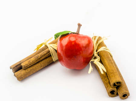 Red apple and cinnamon sticks, isolated against white background, decoration for Christmasの写真素材