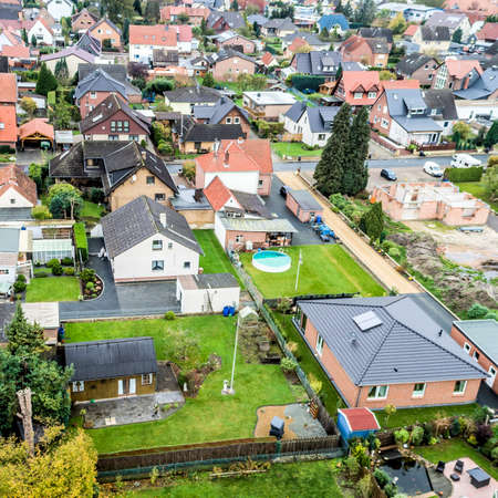 Suburban settlement in Germany with terraced houses, home for many families, taken at a slanting angle with the droneの写真素材