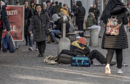 Brunswick, Lower Saxony, Germany, December 7th 2017: Freezing and tired poor beggar in the pedestrian zone in front of the Christmas market of Brunswick.のeditorial素材
