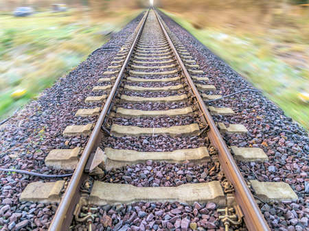 Abstract post-processed photograph of railroad tracks with blurred landscape, central perspective, blurryの写真素材