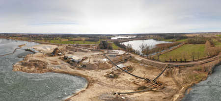 Composite panorama of aerial photographs and aerial photos of a wet quarry for gravel and sand with...
