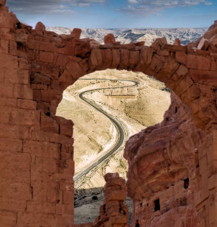 View through a ruin to a steep road with serpentines in the highlands of Jordan, composite photographの写真素材