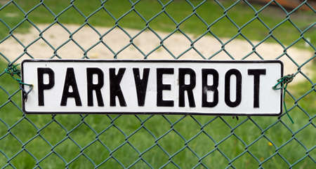 Shield with the German inscription No Parking on a wire mesh fence, germany
