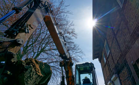 large excavator shovel in the backlight filled with a mighty load of loose brown sand at the construction site, germanyの写真素材