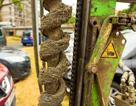 Side view of a auger for water level drilling, filled with sand and gravel, hard work
