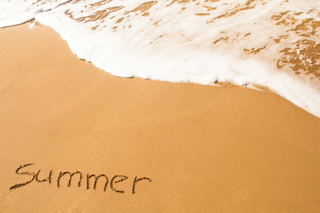 The inscription on the sand is summer washed by a wave.の写真素材