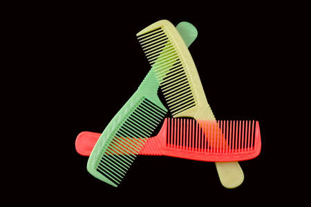 COMBination. Triangle of three coloured plastic combsの写真素材