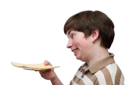 I hate empty plates! - A boy looking with dislike at the plate in his handの写真素材