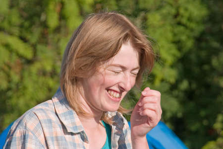 Laughing blonde woman in a checked shirt