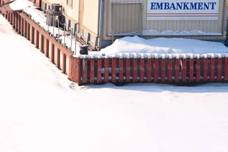Snowy quay at frozen river in winterの写真素材