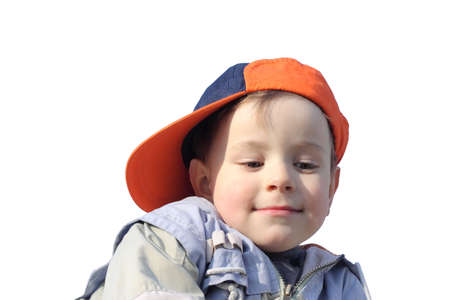 Little boy in orange sideward turned cap looking down,  isolated on white backgroundの写真素材
