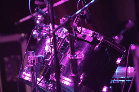 Rock concert series: drum set with microphones, lit by purpleの写真素材