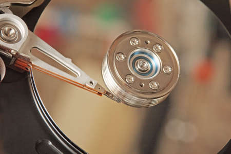 Inside hard drive. Head and surface of disk with colourful reflections