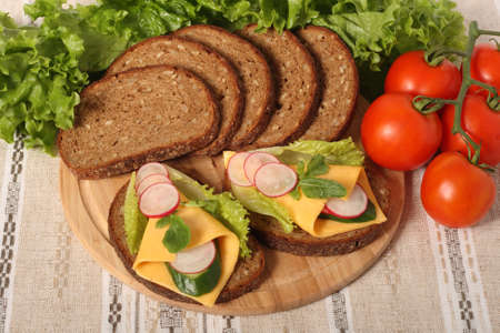 Two sandwiches, bread slices and fresh vegetablesの写真素材