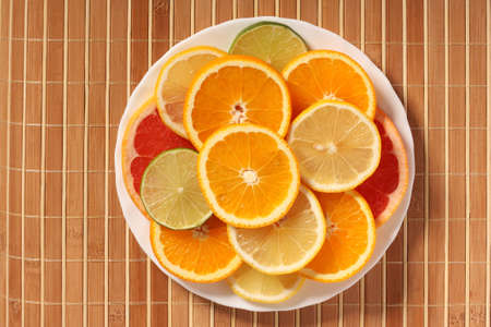 Plateful of citrus slices on bamboo mat, top viewの写真素材