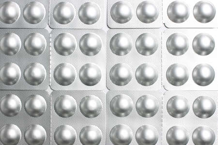 Background of round pills in silvery blisters