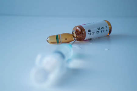 Vaccine bottle and syringe on a blue background. Selective focus.の写真素材