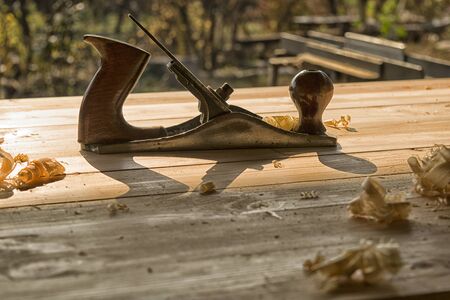 Joinery. Planing a furniture panel made of wood with a manual planer. Side viewの写真素材