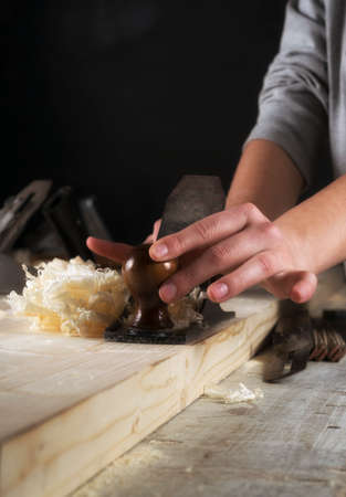 Joinery. Planing a natural wood furniture panel with a manual planerの写真素材