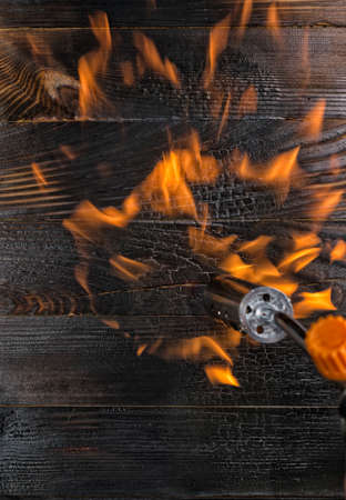 Brushing boards with a gas burner. Annealing pine tabletopsの写真素材
