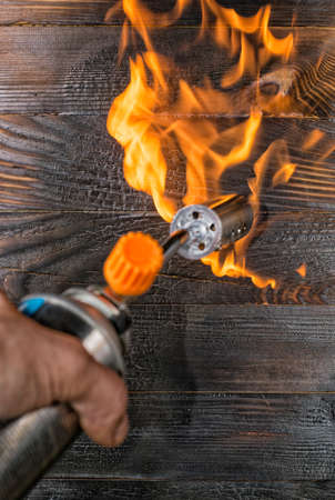 Brushing boards with a gas burner. Annealing pine tabletopsの写真素材