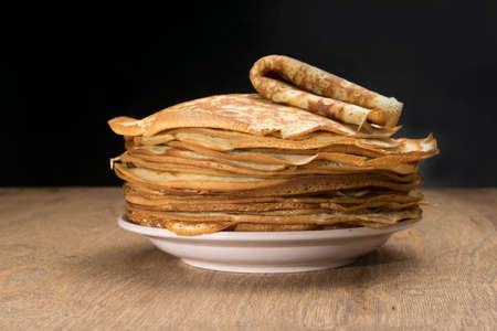 Pancakes in a plate on a wooden tableの写真素材