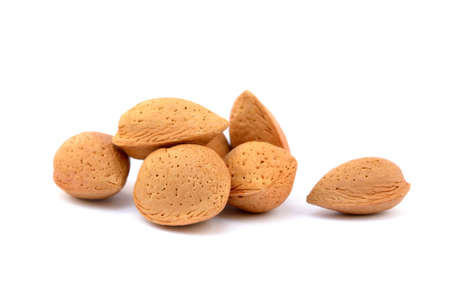 Pile of unpeeled almonds isolated on white backgroundの写真素材