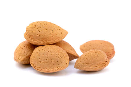 Pile of unpeeled almonds isolated on white backgroundの写真素材