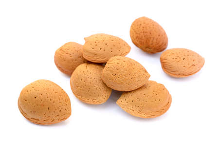 Pile of unpeeled almonds isolated on white backgroundの写真素材