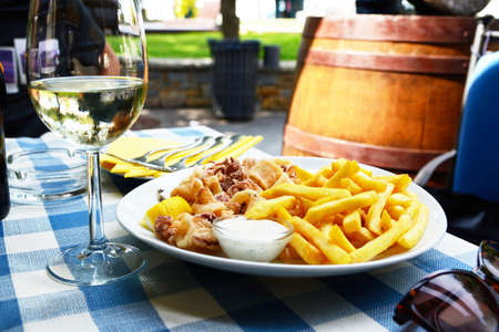 Calamari and fries he laid table in a restaurantの写真素材