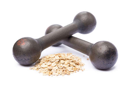 Old gym dumbbells and oat flakes isolated on white backgroundの写真素材