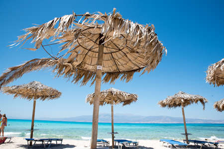 Two Deckchairs Under Parasol In Tropical Beach at quiet sea.の写真素材