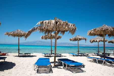 Two Deckchairs Under Parasol In Tropical Beach at quiet sea.の写真素材