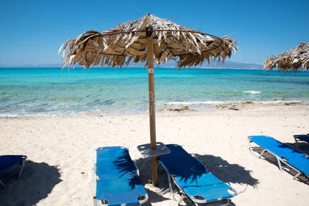 Two Deckchairs Under Parasol In Tropical Beach at quiet sea.の写真素材