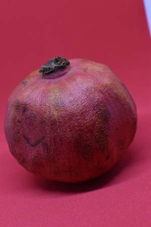 Pomegranate isolated on red background.