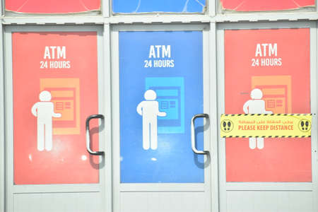 ATM 24 Hour written in red and blue ATM counter entrance.Keep distance words in yellow color.の写真素材