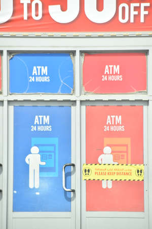 ATM 24 Hour written in red and blue ATM counter entrance.Keep distance words in yellow color.の写真素材