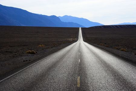 Desert road going through mineral deposits and geological formations of Death Valley National Parkの写真素材