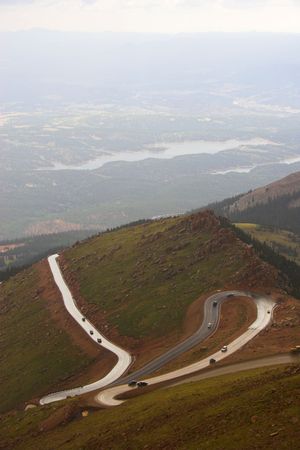 Winding road to Pikes Peak in Colorado surrounded by colorful mountain prairies during drizzle rainの写真素材
