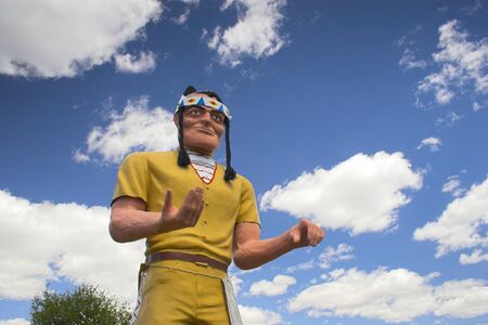 Sculpture of plastic Indian on the background of blue cloudy sky
