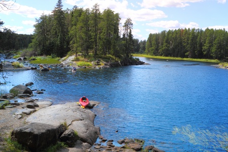 Red canoe sitting on the rocks at the lake in Minnesota, USAのeditorial素材