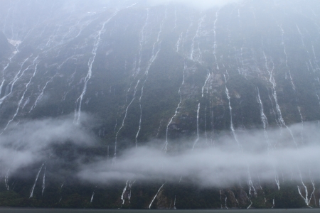 Hundreds of waterfalls flowing from the mountains during the rainstorm in Fiordland National Park, New Zealandの写真素材