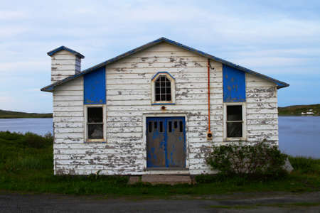 Old weathered white building on the shoreの写真素材